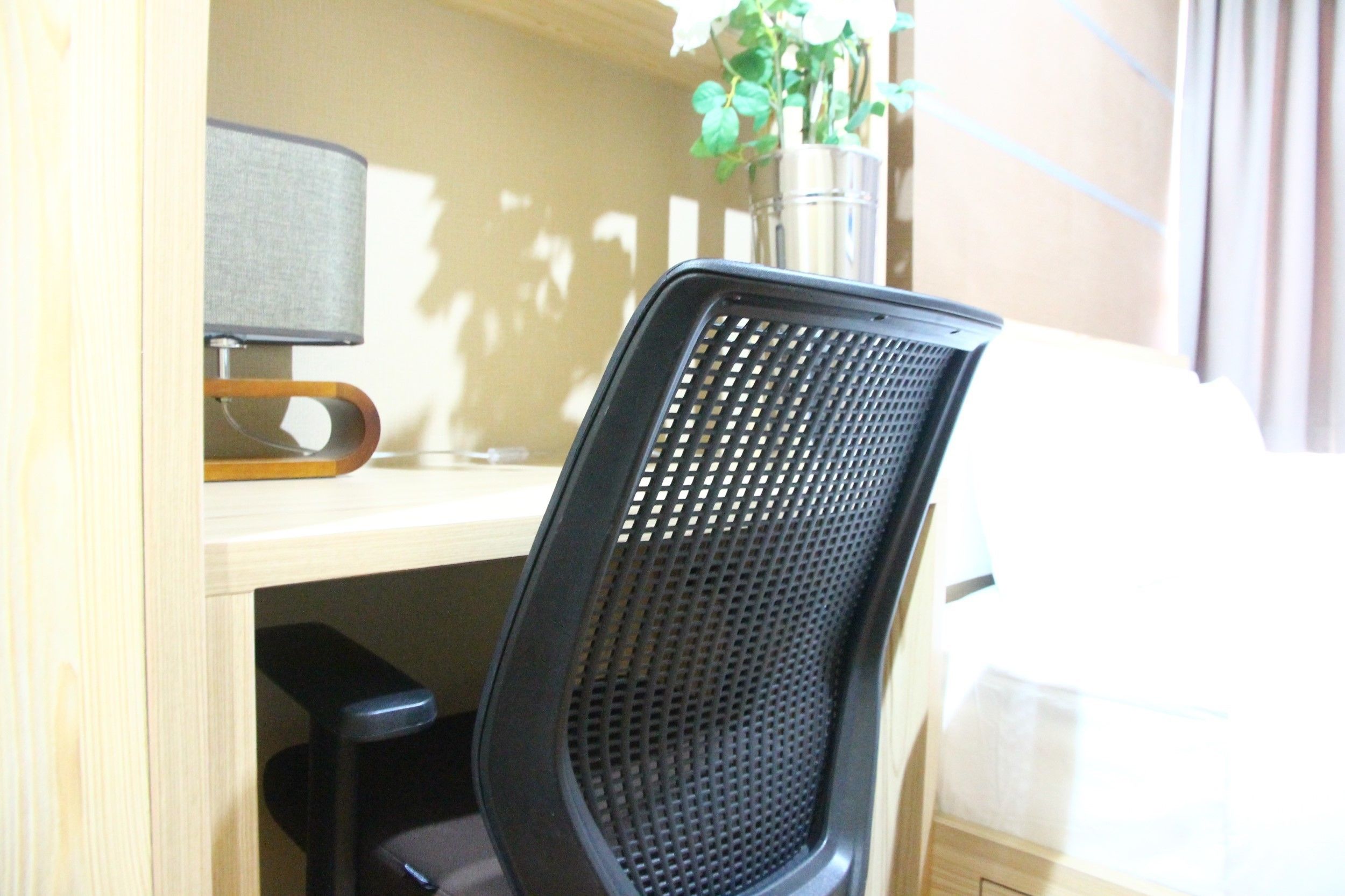A workspace with a computer, a chair, and a small plant.