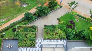 An aerial view of a building with a rooftop garden, a checkered floor pattern, and a gated entrance. - Cozy and Minimalist 1BR @ Oasis Apartment (Cikarang)