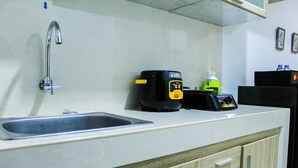 A kitchen with a sink, a coffee maker, and a toaster. - Modern and Comfortable Studio Springwood Apartment (Tangerang)