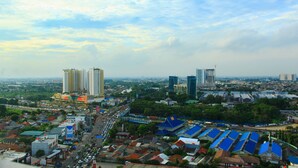 A cityscape with high-rise buildings, a busy street, and a mix of residential and commercial structures. - Modern and Comfortable Studio Springwood Apartment (Tangerang)