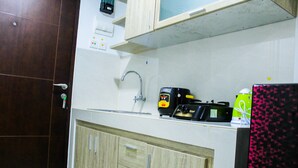 A kitchen with a microwave, kettle, and kettle on the counter. - Modern and Comfortable Studio Springwood Apartment (Tangerang)