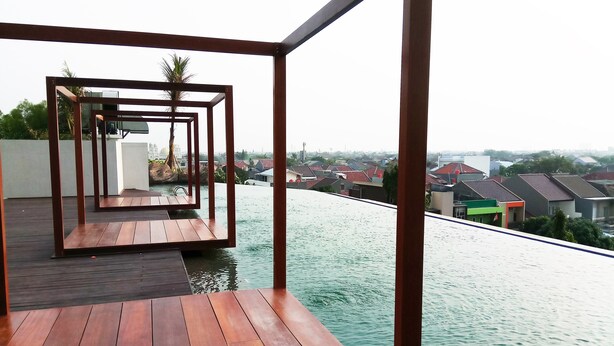 Una terraza de madera con vistas a una zona residencial y un cuerpo de agua.