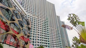 Un edificio de gran altura con un diseño arquitectónico moderno, que presenta una cuadrícula de ventanas y balcones.