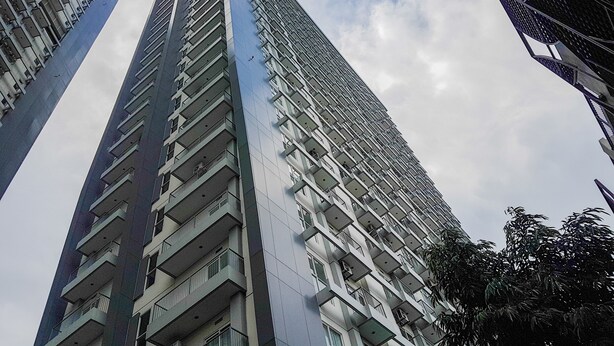 A high-rise building with multiple balconies, large windows, and a modern architectural design. - Simply Homey Studio Casa De Parco Apartment (Pagedangan)