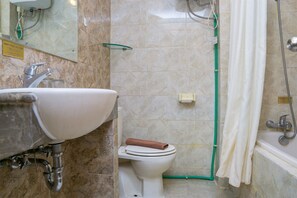 Casa de banho com lavatório, sanita e zona de duche.