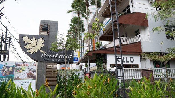 Une enseigne d’hôtel avec un logo en forme de feuille et le nom « Cimbolut ».