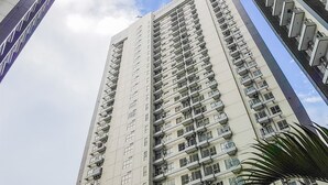 A high-rise residential building with multiple balconies and a clear sky. - Nice & Comfy Studio Apartment Casa De Parco (Pagedangan)