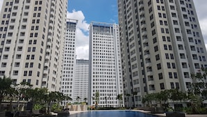Ein Hochhaus mit mehreren Balkonen und einem Pool im Vordergrund.