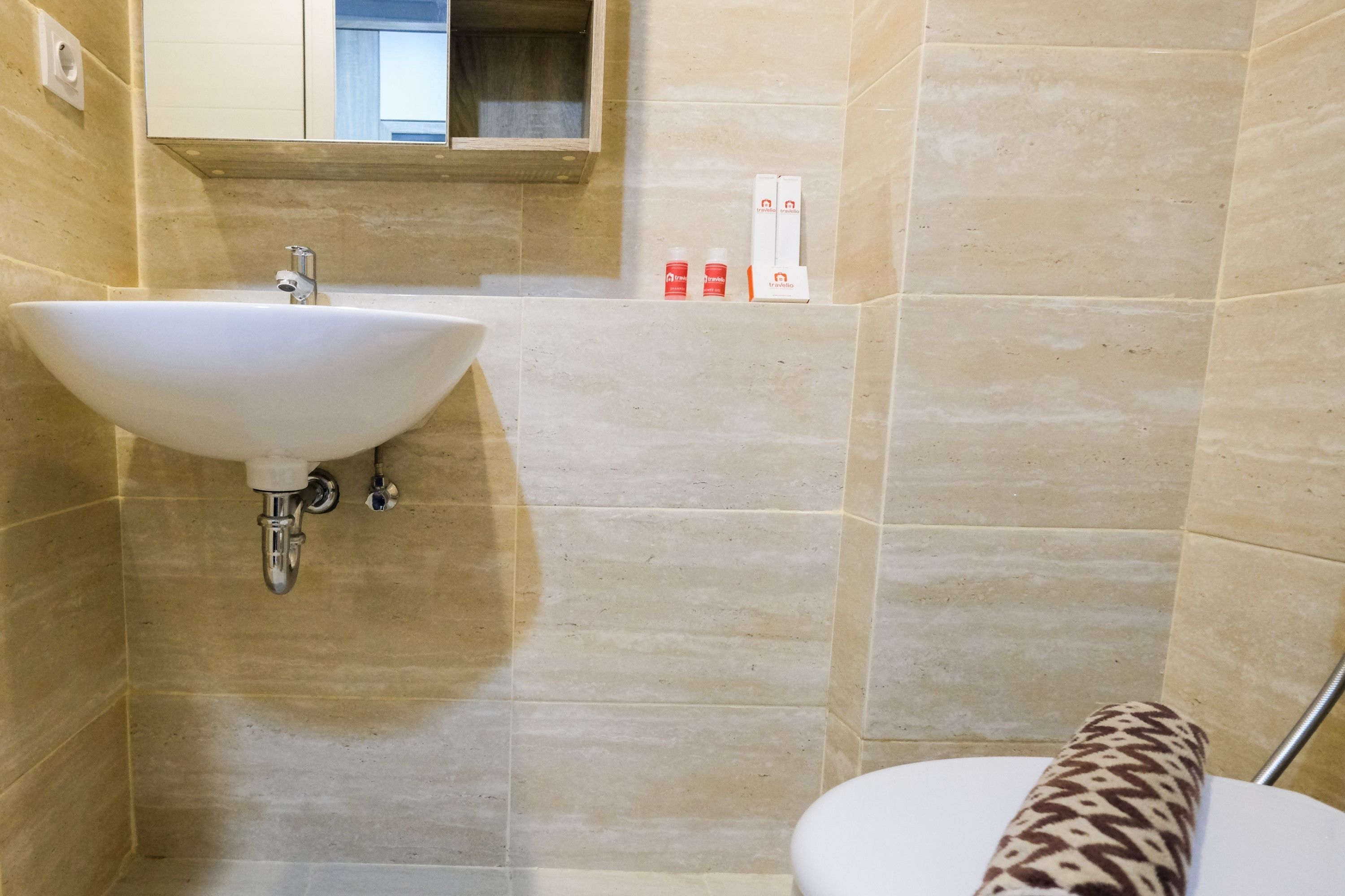 Une salle de bain avec un lavabo blanc, un miroir et des toilettes.