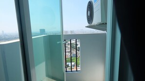 A high-rise building with a view of a cityscape through a window with metal bars. - Fabulous Tree Park City Studio Apartment near ICE BSD (Tangerang)