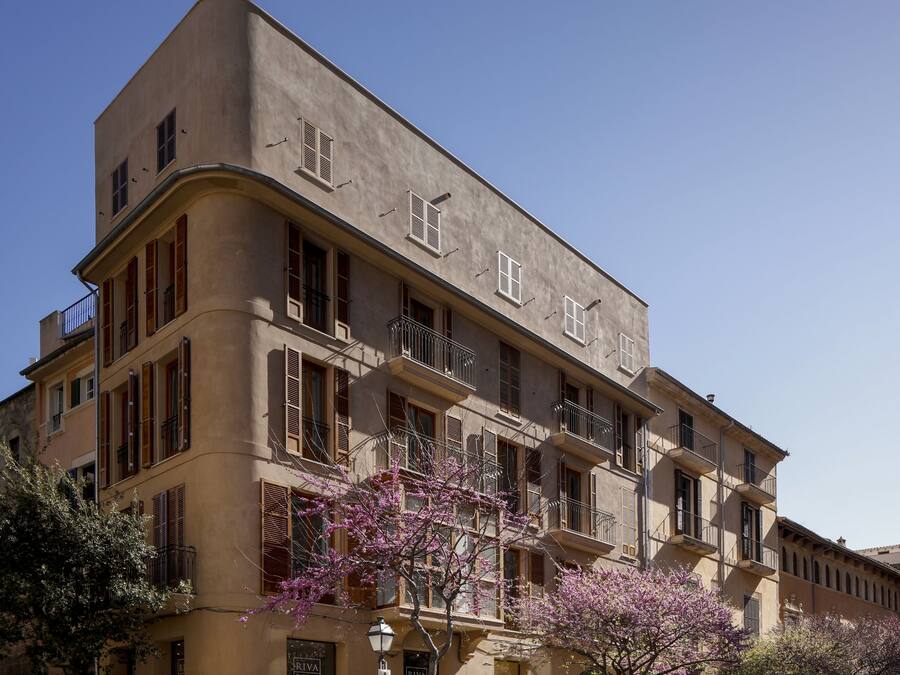 Un edificio de varios pisos con balcones y un estilo arquitectónico clásico.