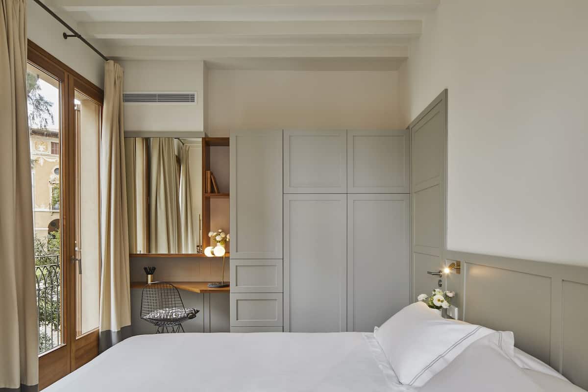 Une chambre à coucher avec un lit, une chaise, un bureau et une armoire.
