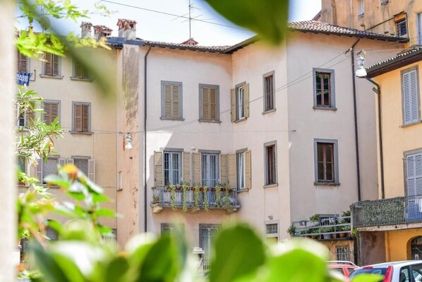 A narrow street with buildings featuring balconies and shutters. - Casa di Sofia Città Alta (Bergamo)