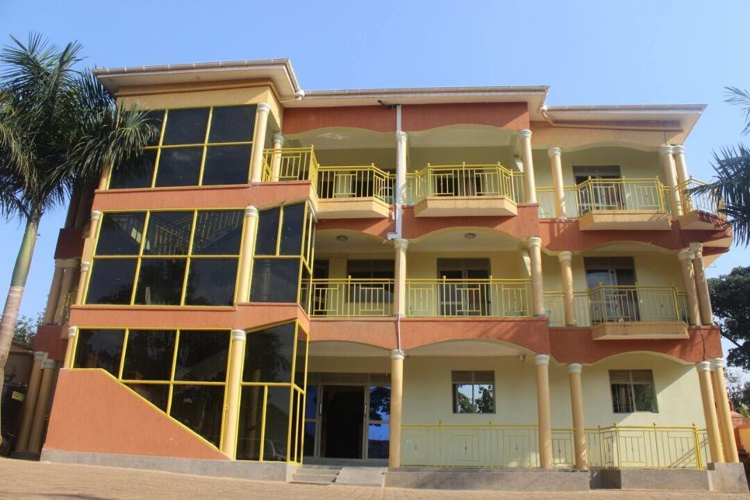 A multi-story building with balconies, large windows, and a flat roof.