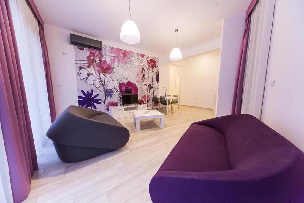 Een moderne woonkamer met een bank, een salontafel en een eethoek met stoelen.