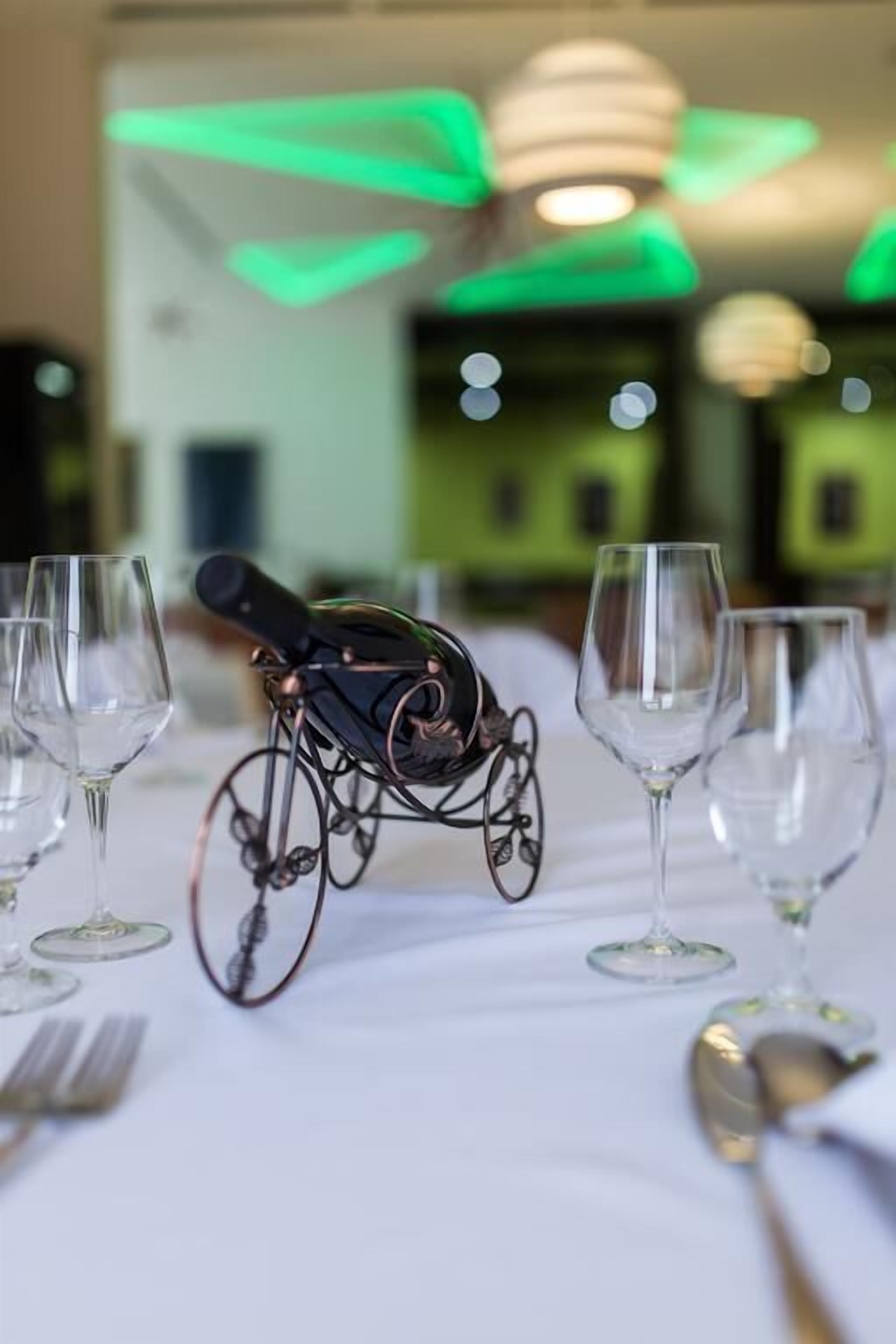 Ein Esstisch mit leeren Weinkellen und einem weinregal in Fahrradform.