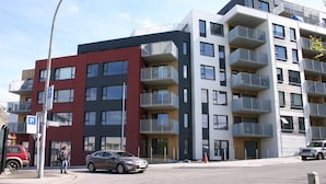 A multi-story residential building with balconies, a parking sign, and a street view. - Nest Apartment Sparrow (Reykjavik)