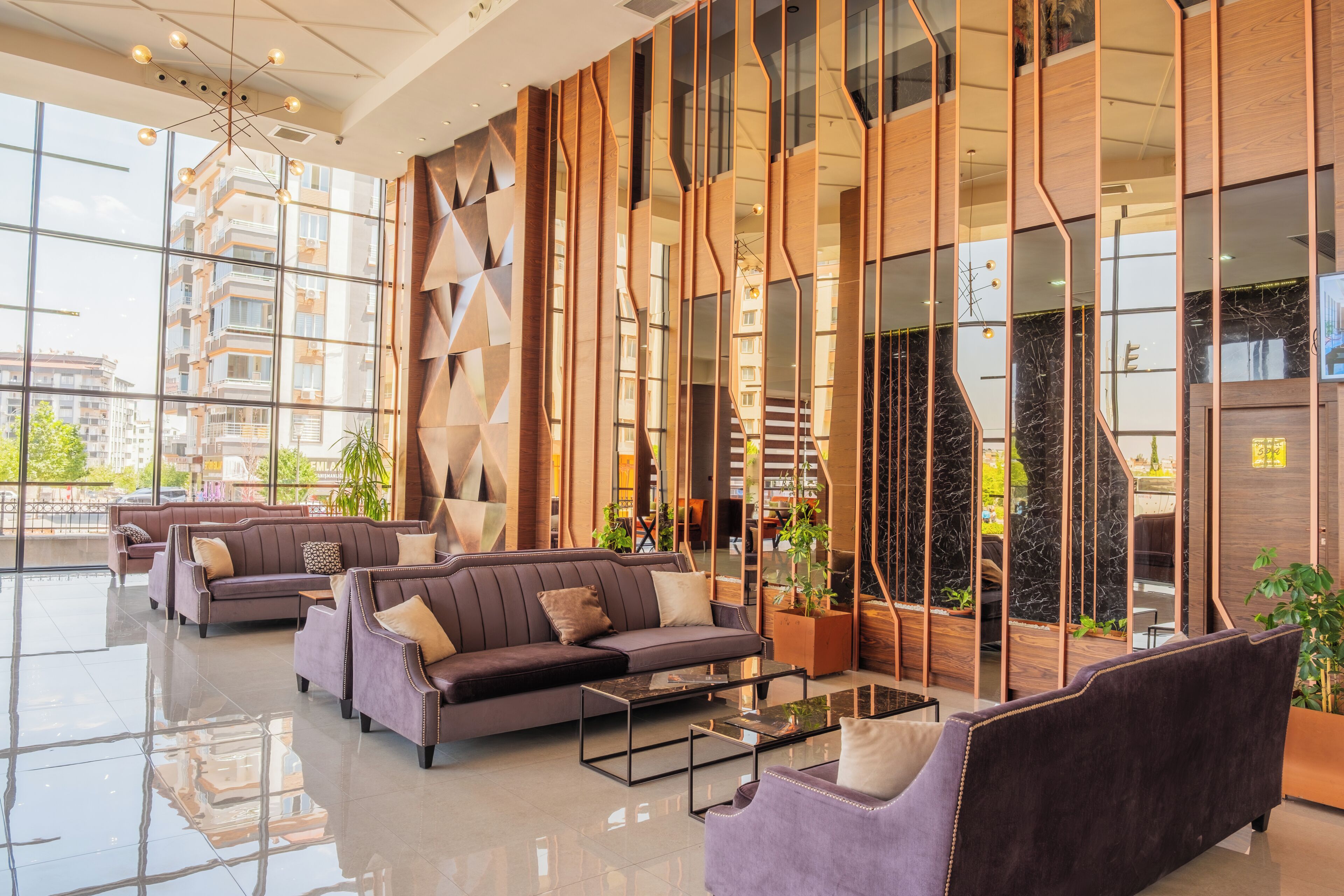 Een ruime lobby met moderne inrichting, grote ramen en uitzicht op de skyline.