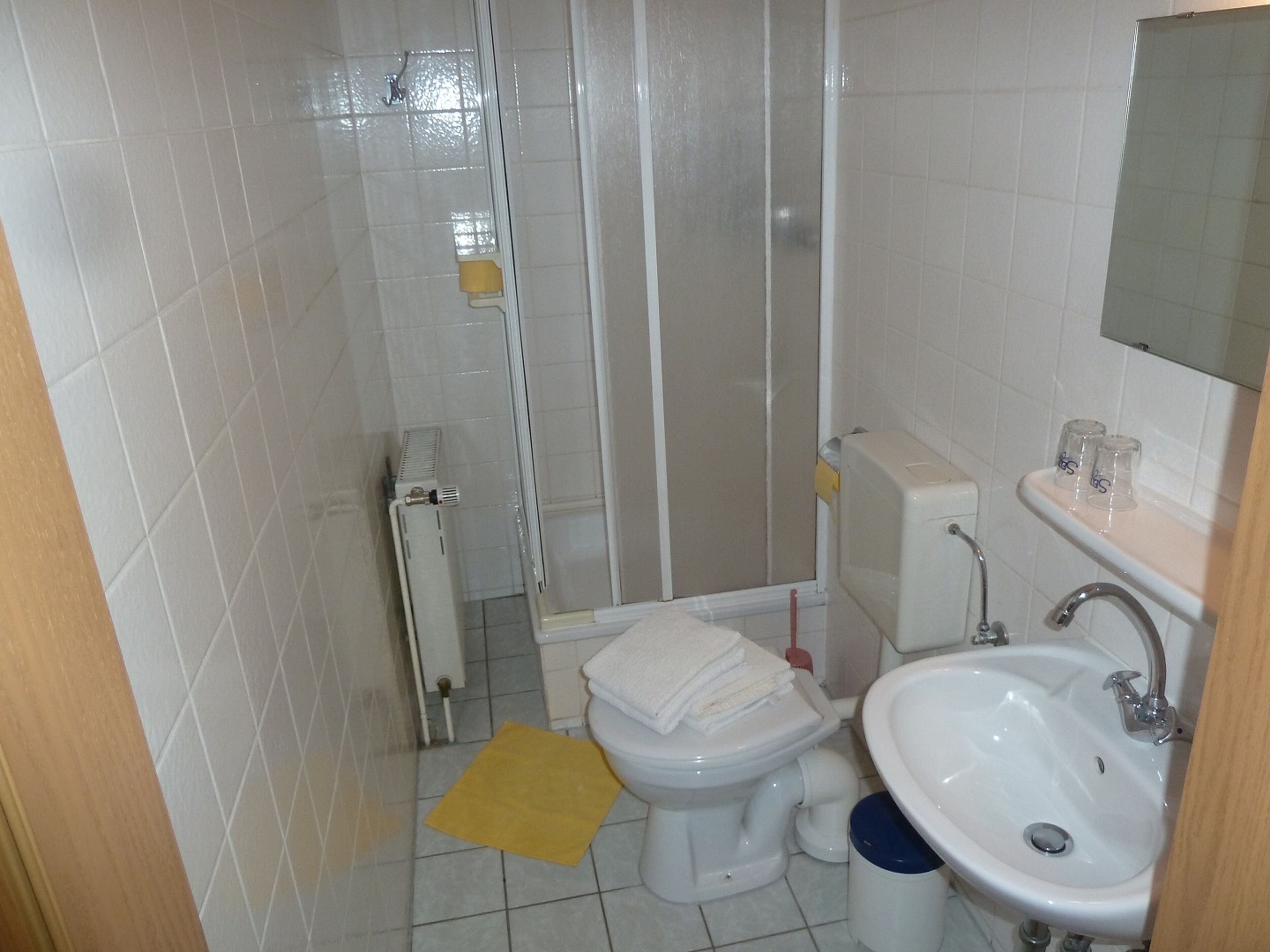 Un baño pequeño con inodoro, lavamanos y ducha.
