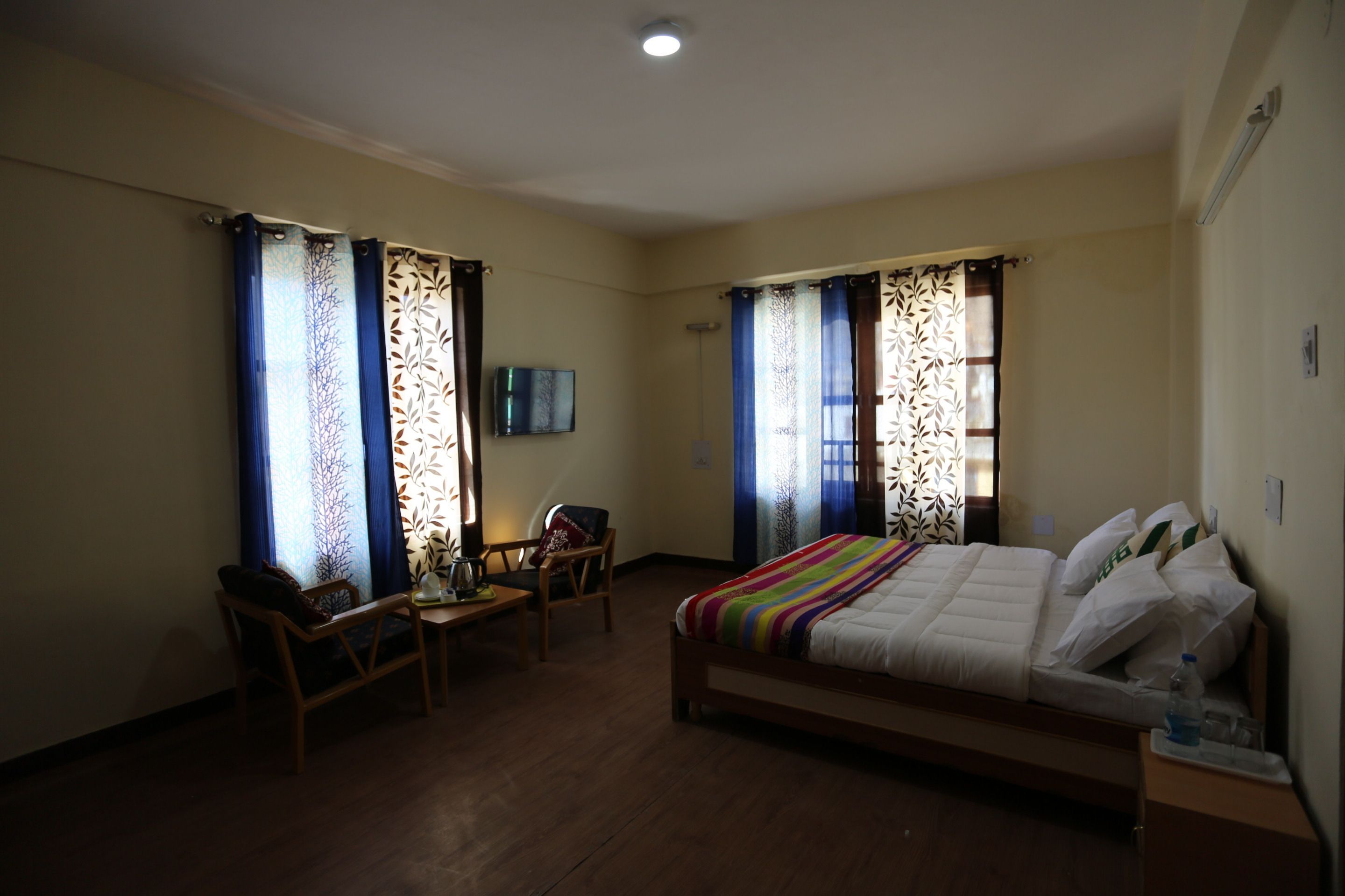 Una habitación de hotel con cama, escritorio, silla y televisión.