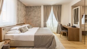 Un dormitorio moderno con una cama grande, un escritorio y un armario.