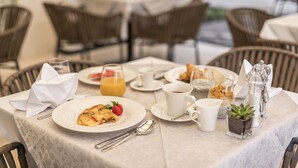 A breakfast table set with plates, cups, and a small potted plant. - Residence Stine (Split)