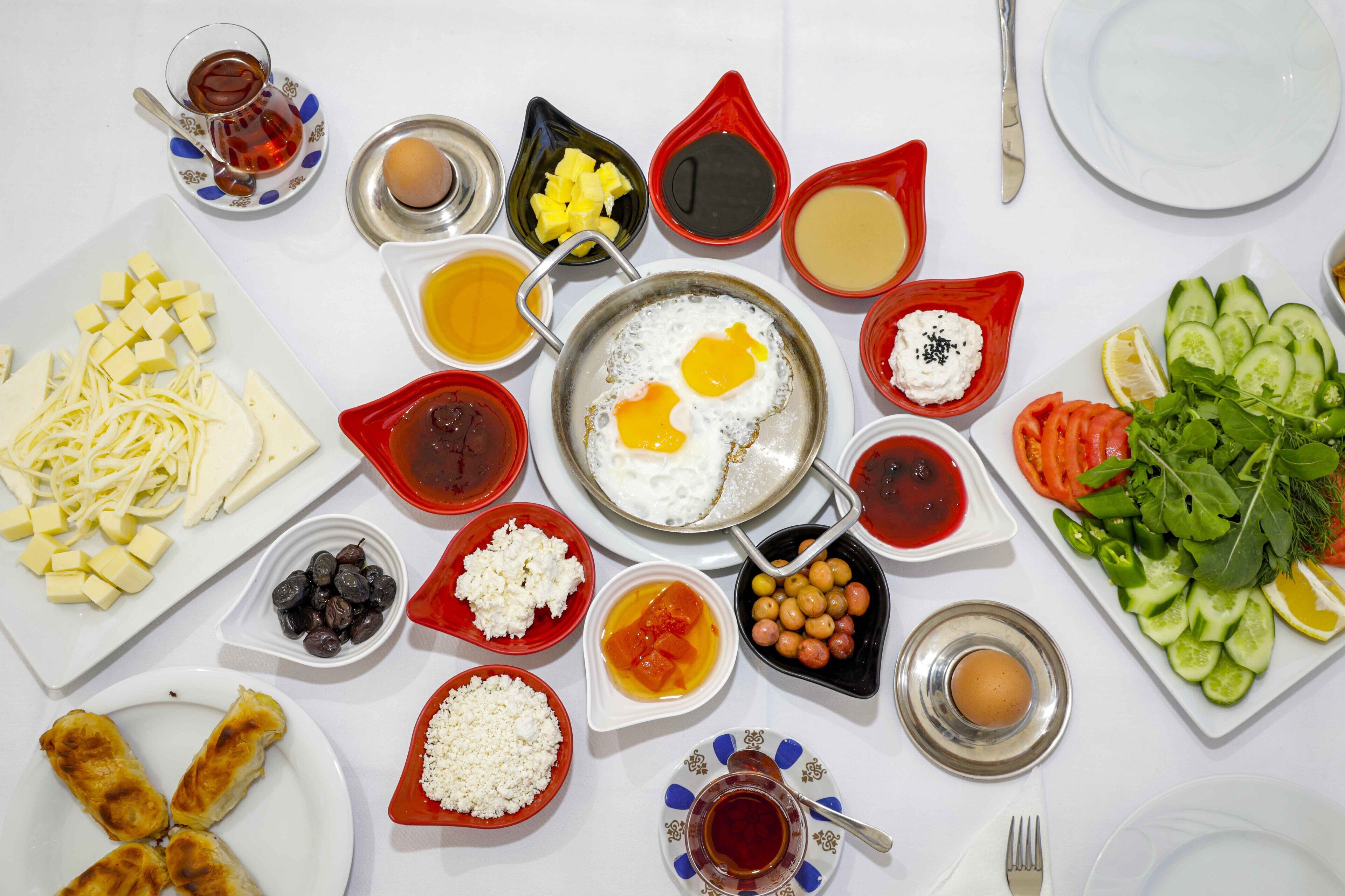 A table with various dishes including eggs, cheese, olives, and vegetables.