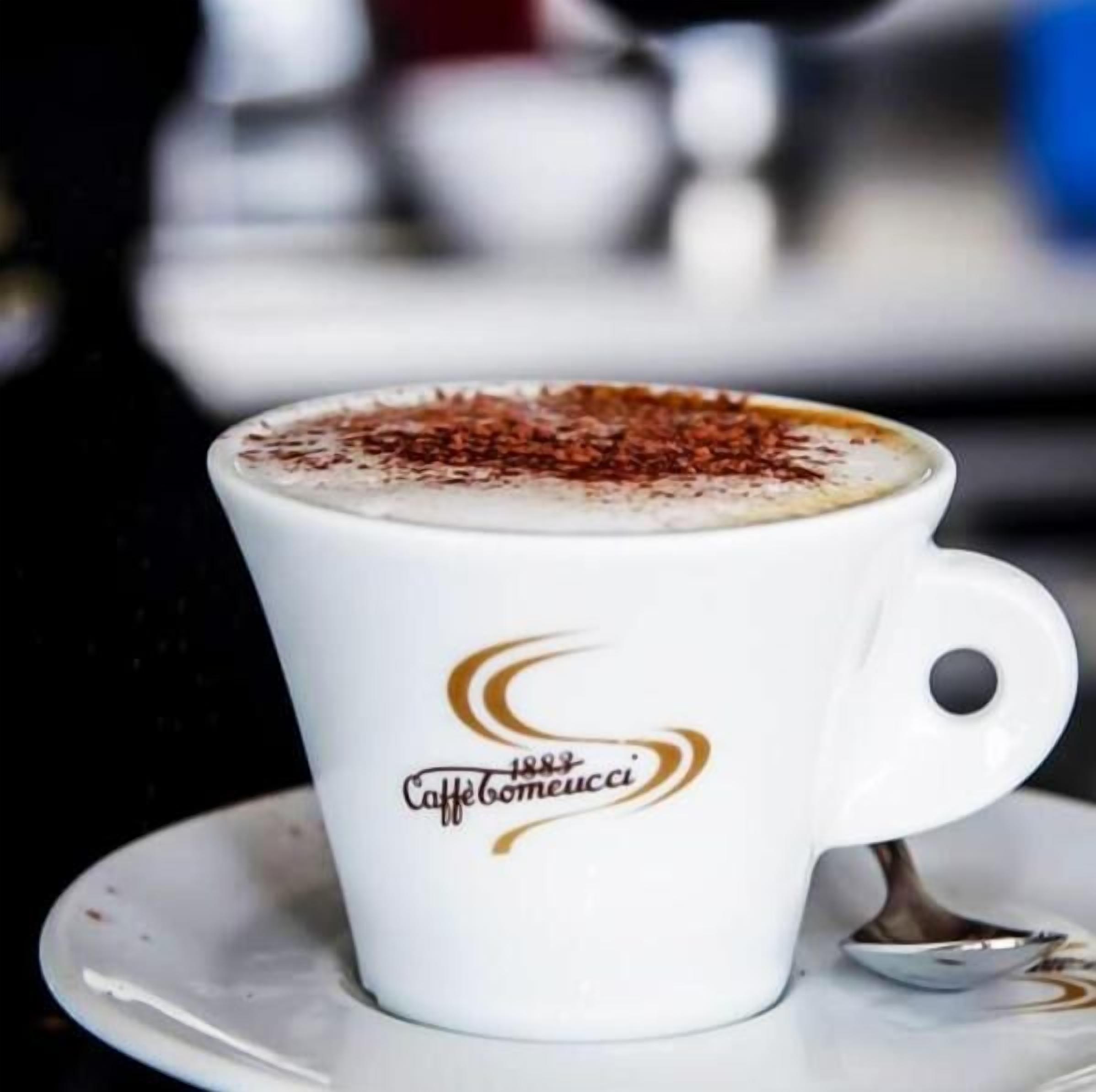 A white cup with a logo and text on it, placed on a saucer.