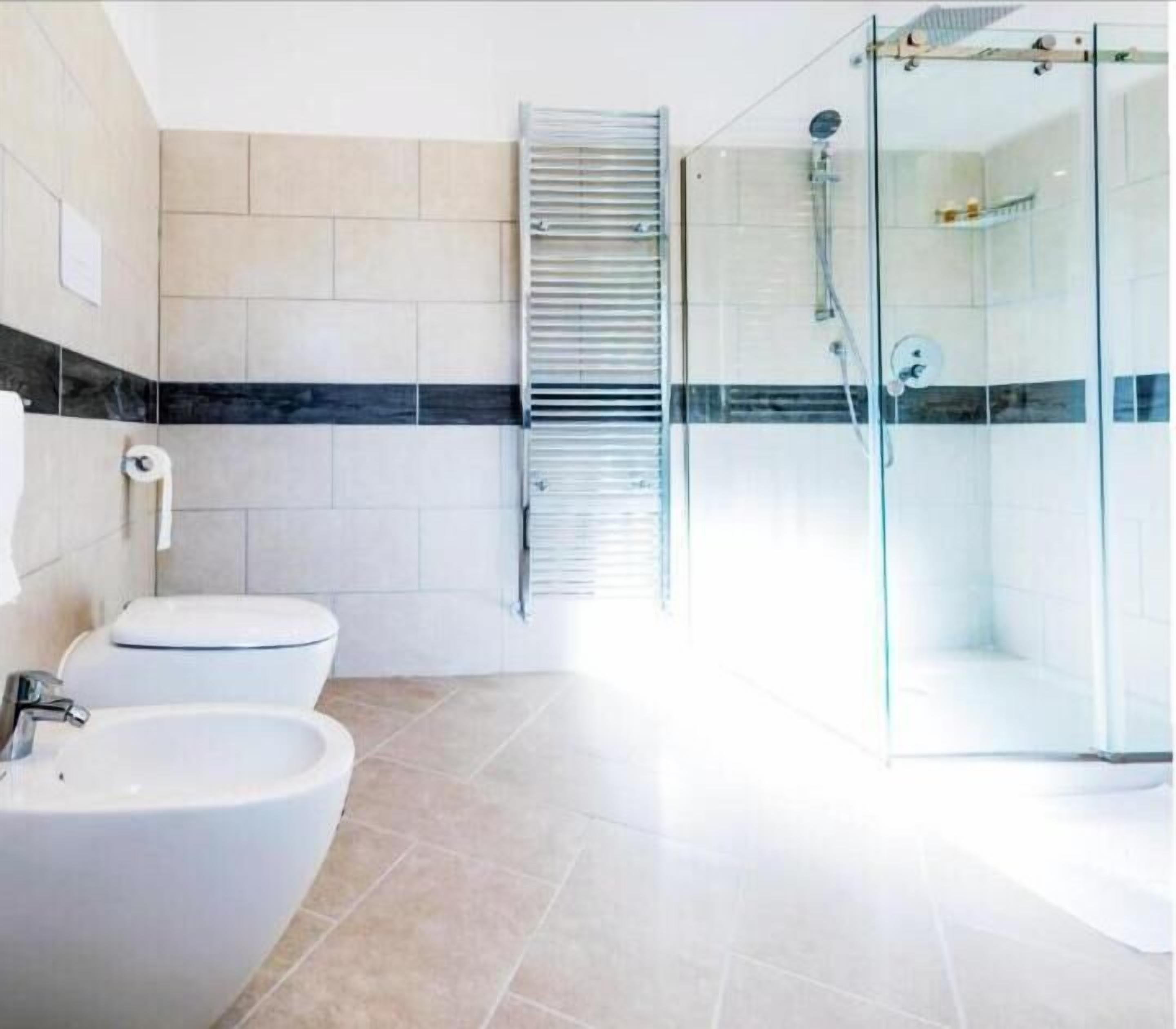Un baño moderno con cabina de ducha de vidrio, inodoro y bidé.