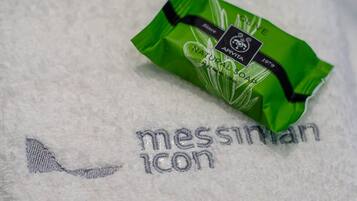 A green package of natural soap on a white towel with embroidered text.