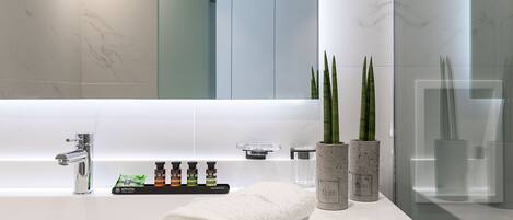 A modern bathroom with a white sink, a mirror, and a glass shower enclosure.