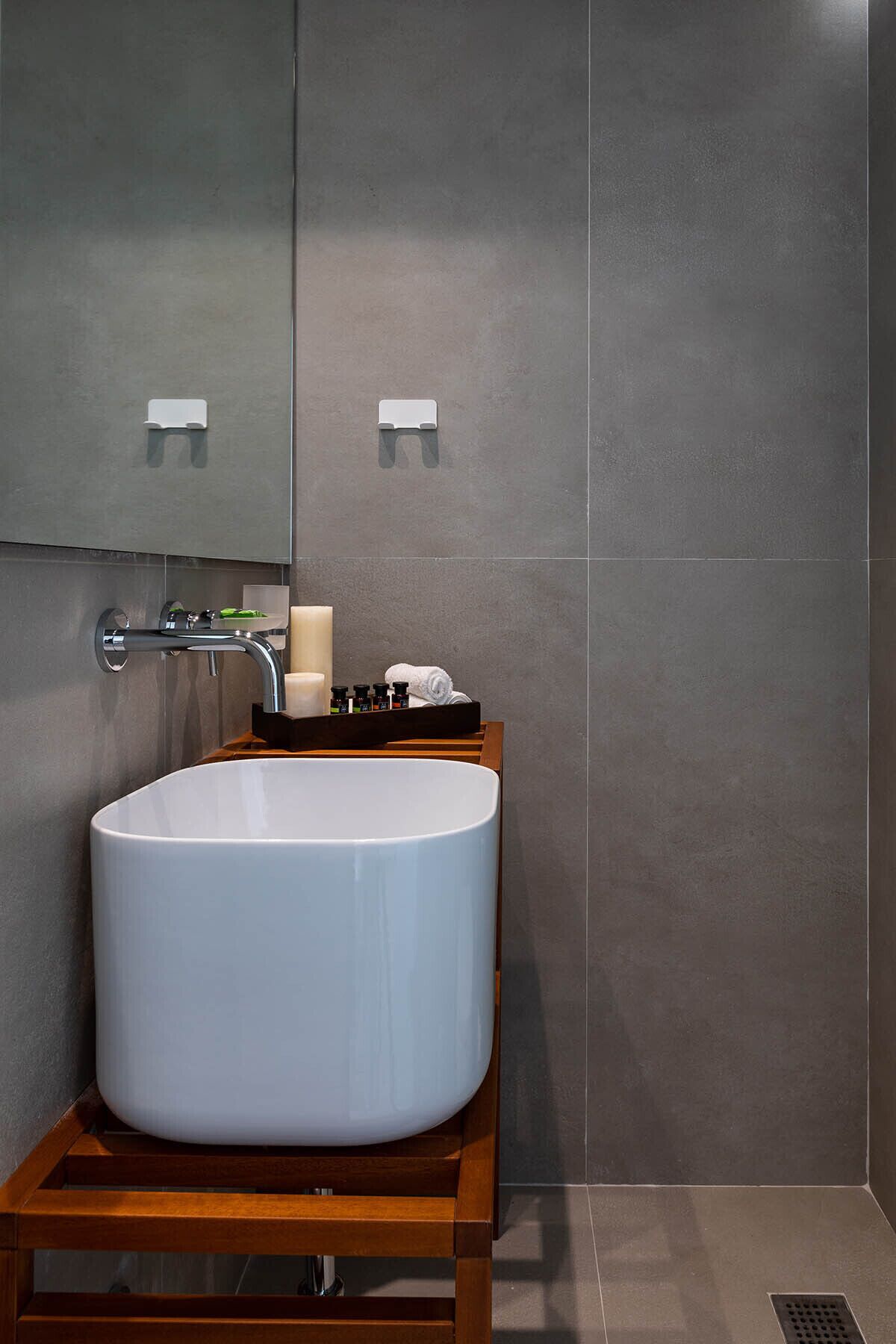 Un baño moderno con un lavabo blanco grande, un espejo sobre él y un mueble de tocador de madera.