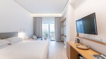 Habitació d'hotel moderna amb un llit gran, un televisor penjat a la paret, escriptori amb un búl i un balcó amb vistes.