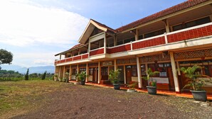 A two-story building with a red-tiled roof and a balcony. There are potted plants in front of the building. - Hotel Agung Permata Artha (Garut)