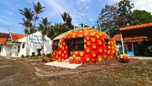 A uniquely designed building with a mushroom-like structure, a visible sign for 'Hotel Alung Permata', and a red-tiled roof. - Hotel Agung Permata Artha (Garut)