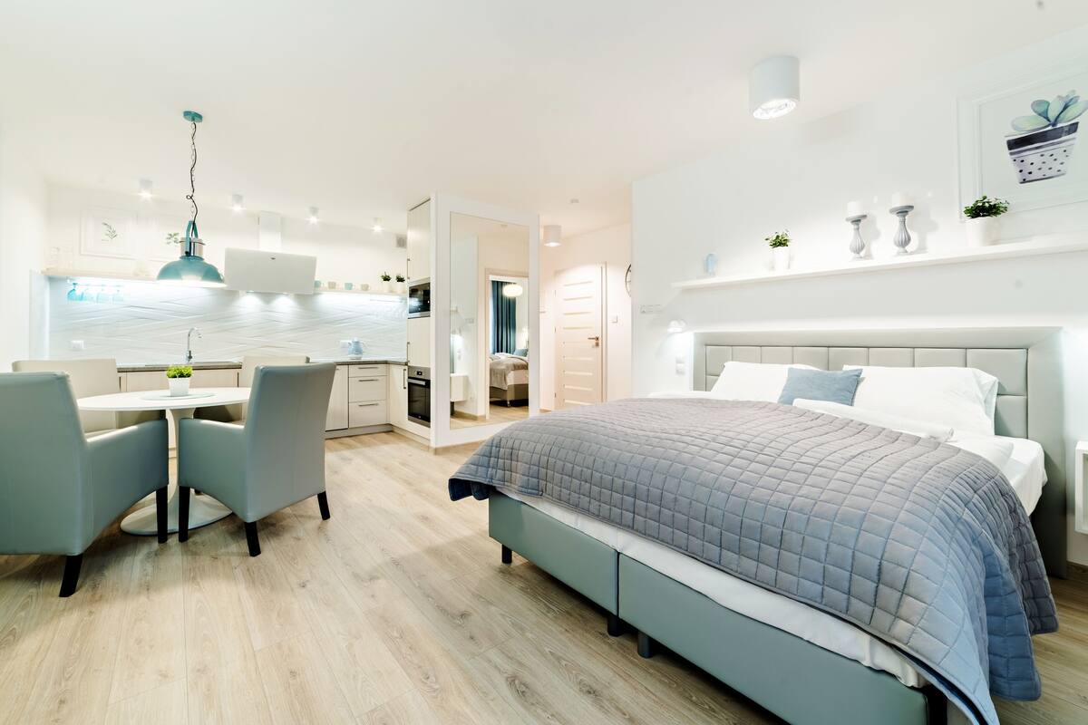 A modern bedroom with a large bed, a desk, and a chair.