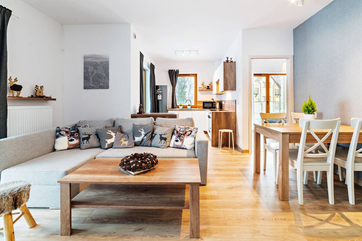A modern living room with a sofa, coffee table, and dining area.