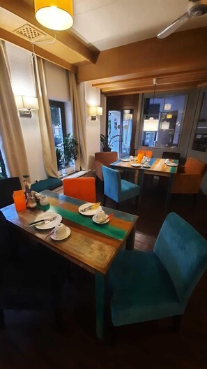 Enjoy dining in this inviting space with a wooden table, comfortable chairs, and a warm atmosphere.