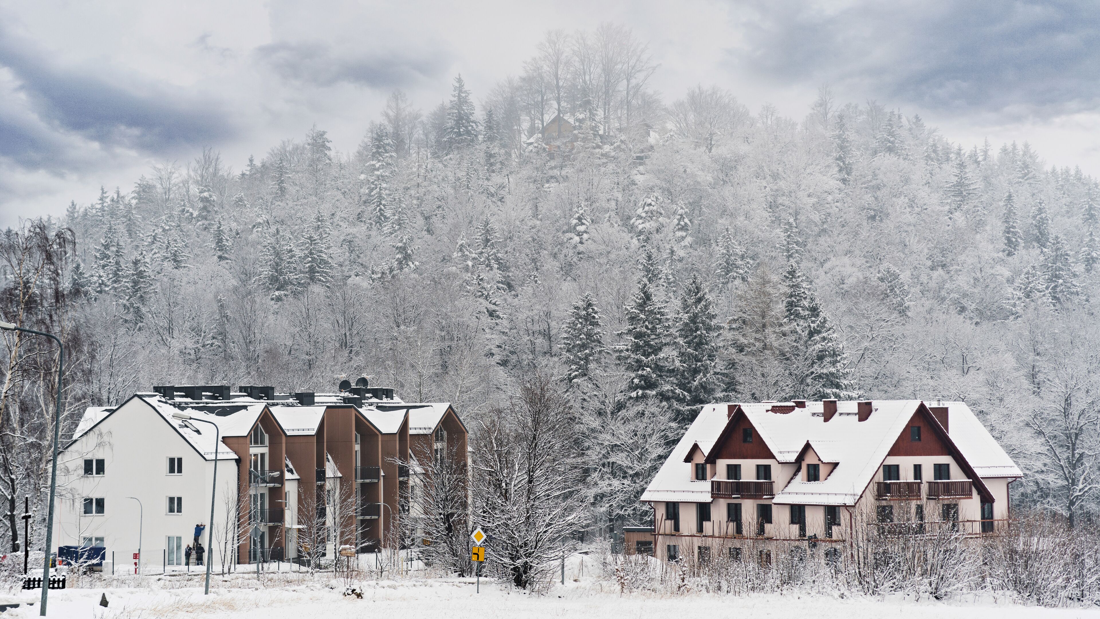 A hotel with multiple buildings, surrounded by a snowy forest.