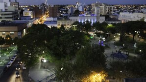 A nighttime cityscape with a prominent church tower and a well-lit plaza. - Hotel Salto Grande (Concordia)