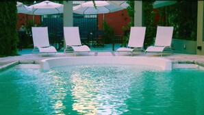 An indoor swimming pool with lounge chairs and umbrellas. - Hotel Salto Grande (Concordia)