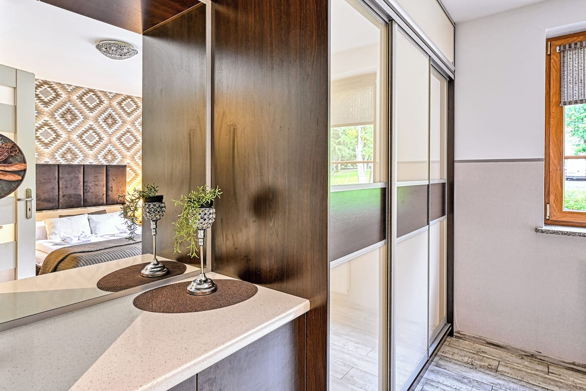 Un baño moderno con un espejo grande, un lavamanos y un panel decorativo en la pared.