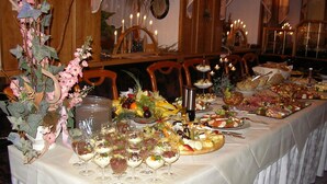 A long dining table set with various dishes, glasses, and a centerpiece. - Hotel Goldene Sonne (Annaberg-Buchholz)
