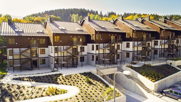 A modern multi-story building with multiple balconies and staircases.