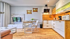 A modern kitchen with white cabinetry, a wooden countertop, and a built-in microwave.