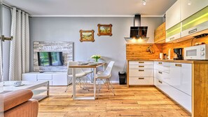 Eine moderne Küche mit weißen Schränken, einer Holz Arbeitsplatte und einer eingebauten Mikrowelle.