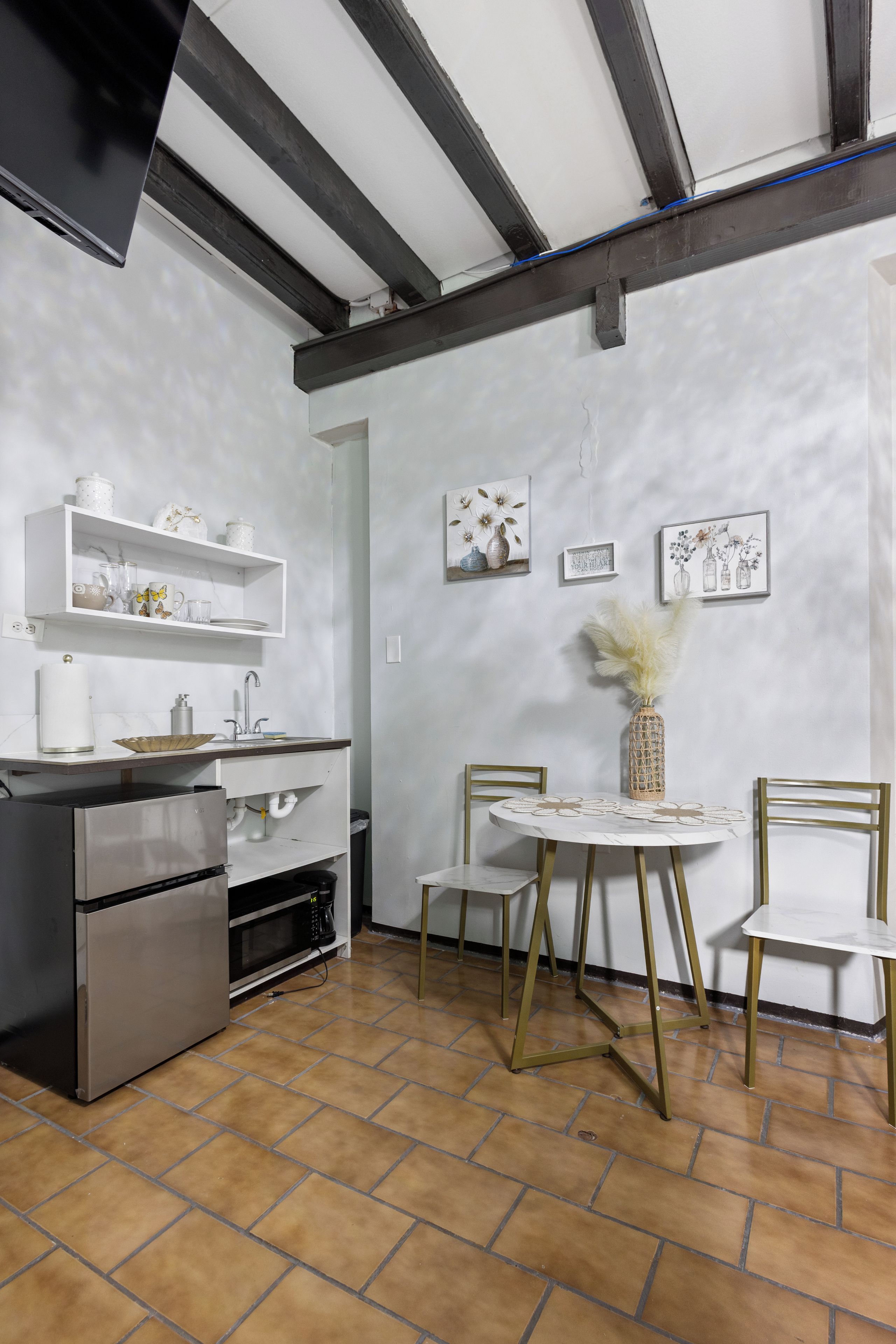 A kitchen with a built-in oven, a sink, and a dining area with a table and chairs.