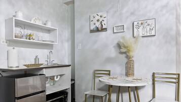 A kitchen with a built-in oven, a sink, and a dining area with a table and chairs.