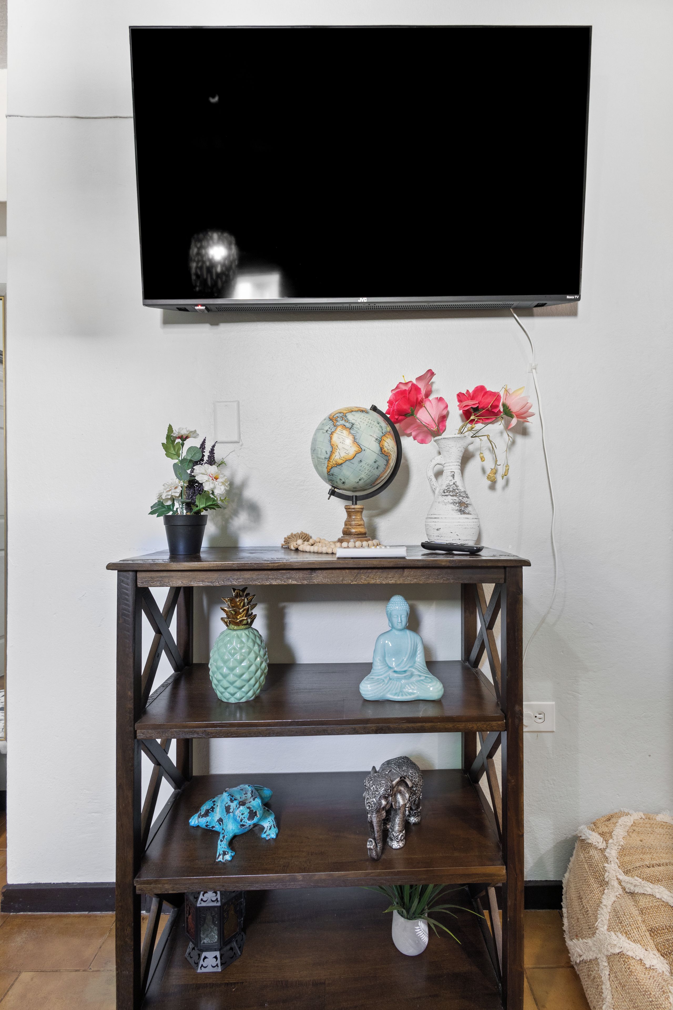 Ein Holz-TV-Schrank mit Globus, Blumen und Dekorationselementen.