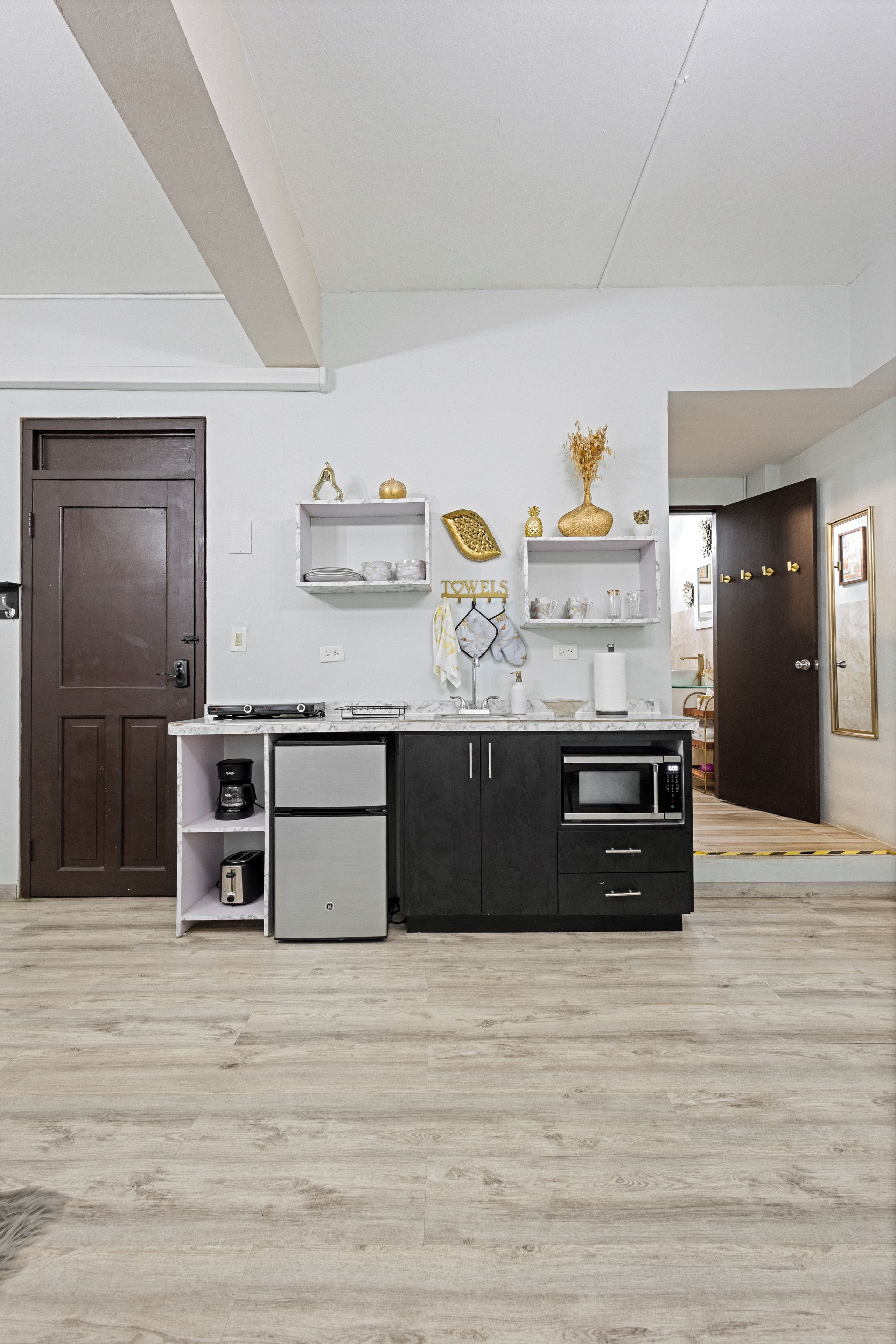 A modern kitchen with a built-in oven, a coffee maker, and a refrigerator.
